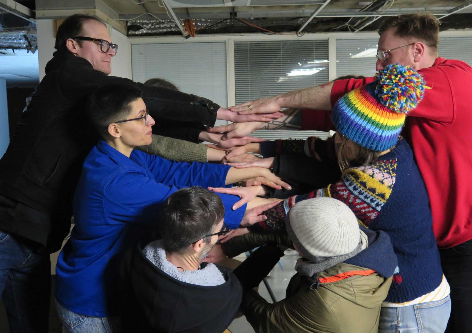 6 people making a wall interlinking their hands